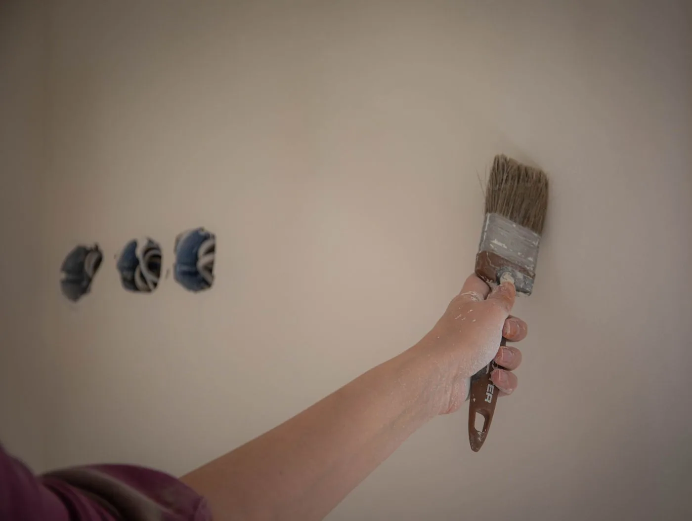 Een schilder werkt een wand met een kwast nauwkeurig af