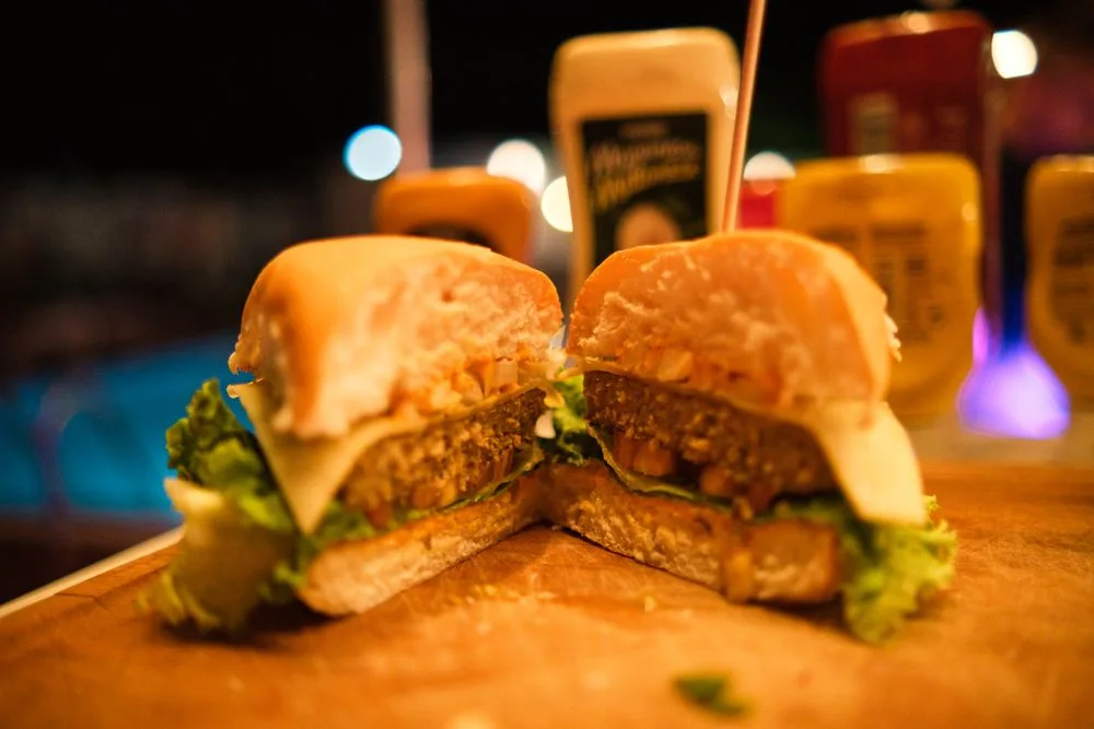 Een doorgesneden burger op een houten plank